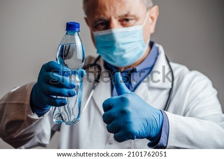Medical doctor recommending plenty of water Royalty-Free Stock Photo #2101762051