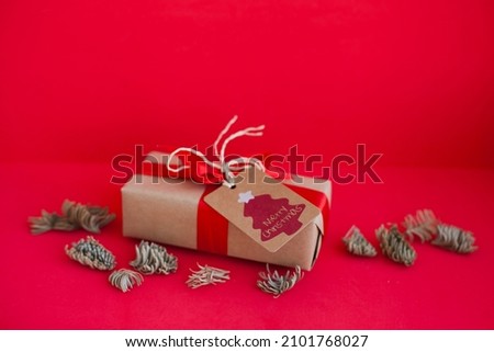 christmas gift box with red ribbon and paper tag as minimal red holidays season background	
