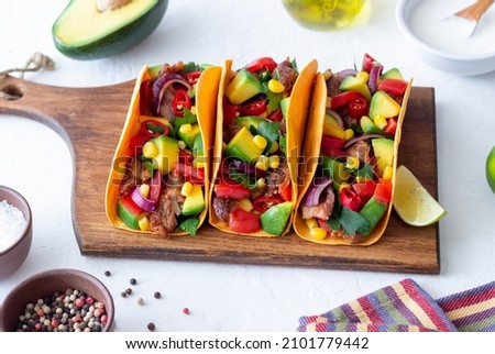Tacos with pork, avocado, tomatoes, corn and onions Mexican food