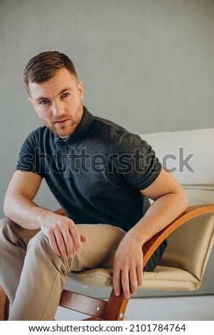 Handsome man sitting in chair in studio