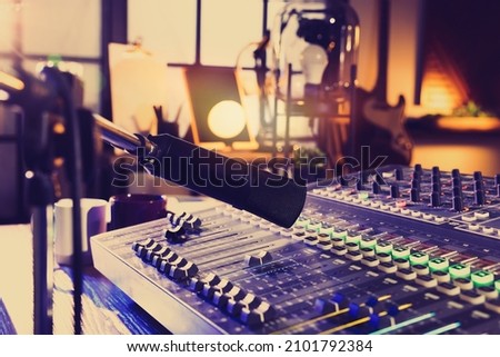 Microphone over professional mixing console on table in radio studio