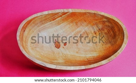 Wooden kitchenware that gives a classic and minimalist impression. food and drink concept. 
Wooden bowl isolated on a red table. Flat lay, High Angle view. 