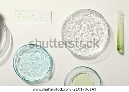 Flat lay composition with cosmetic gel and laboratory glassware on white background
