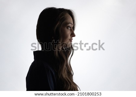 Silhouettes of a young girl with long curly hair on a white background.