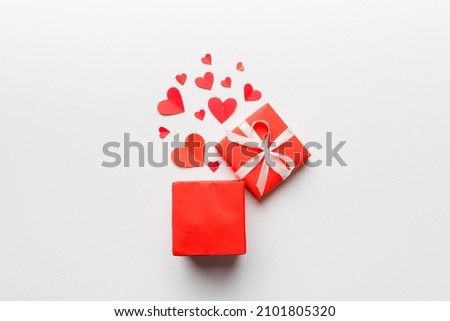 Happy valentines day opened heart shape gift box with small hearts, on colored background, valentines day card - top view concept.