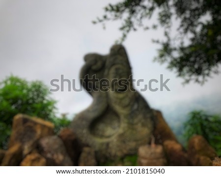 Unfocus photo a statue that is used as a medium of worship that is on top of a mountain