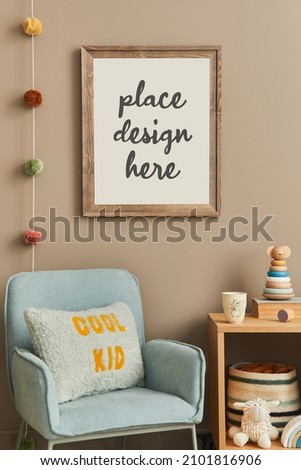 Cozy interior of child room with mint armchair, brown mock up poster frame, toys, teddy bear, plush animal, decoration and hanging cotton colorful balls. Beige wall. Warm kid space.  Template. 