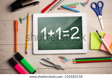 Composite image of digital tablet on students desk showing math equations