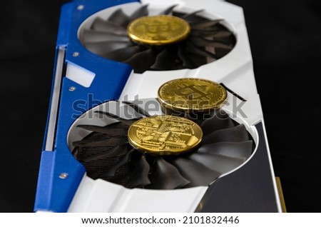 Video card (graphic card) with gold coins symbolizing bitcoin. Cryptocurrency mining concept. Close up. Dark background
