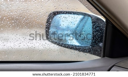 Rain drops on a side glass and window of a car
