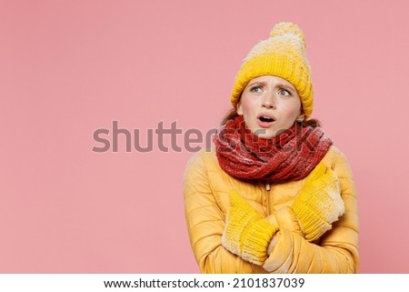 Shocked shocked amazed young woman 20s years old wears yellow jacket hat mittens look aside keep mouth open hold hands crossed frowning isolated on plain pastel light pink background studio portrait Royalty-Free Stock Photo #2101837039