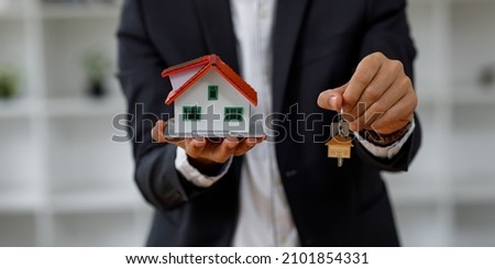 Close up house model with business man signs a purchase contract or mortgage for a home, Real estate mortgage concept.