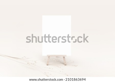 Mockup of an empty white card on a wooden table easel with a minimal neutral background Royalty-Free Stock Photo #2101863694
