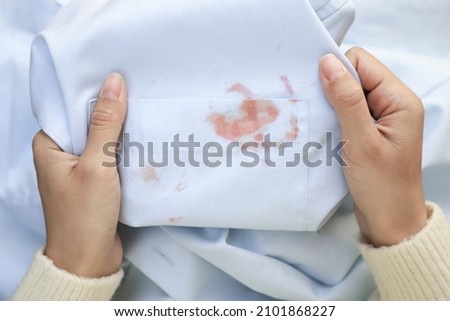 Hand showing dirty cosmetic stain on white shirt from unexpected accident. daily life stain concept Royalty-Free Stock Photo #2101868227