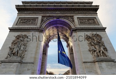 The Triumphal Arch decorated with European flag, Paris, France. It is one of the most famous monuments in Paris. It honors those who fought and died for France. Royalty-Free Stock Photo #2101894099
