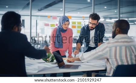 Multi-Ethnic Office Conference Room Businesspeople Meeting at Big Table. Diverse Team of Creative Entrepreneurs Talk, Use Laptop. Specialists work in Digital e-Commerce Startup. Royalty-Free Stock Photo #2101929247