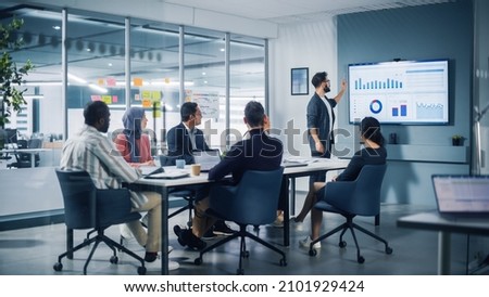 Diverse Modern Office: Motivated Latin Businessman Leads Business Meeting with Managers, Talks about Company Growth, Uses TV for Presentation. Creative Digital Entrepreneurs Work on e-Commerce Project
