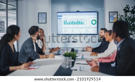 Multi-Ethnic Office Conference Room Meeting: Diverse Team of Managers, Executives Talk, Uses Wall TV with Big Data Analysis, Charts and Infographics. Businesspeople Investing in e Commerce Startup Royalty-Free Stock Photo #2101929514