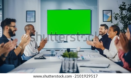 Modern Multi-Ethnic Office Conference Room Meeting: Diverse Team of Successful Managers, Executives Use Green Screen Chroma Key TV, Celebrate and Applaud Successful e-Commerce Product Release