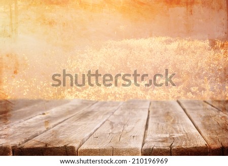 wood board table in front of summer landscape with lens flare. textured image