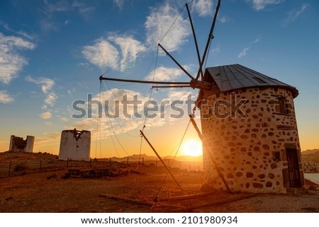 An old windmill on a hill in Bodrum, Turkey. Beautiful scenic sunset. Royalty-Free Stock Photo #2101980934