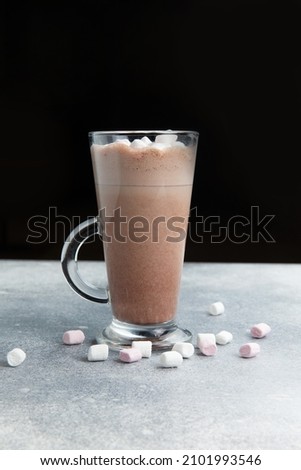 Coffee drink with marshmallows in a glass. On a gray background.