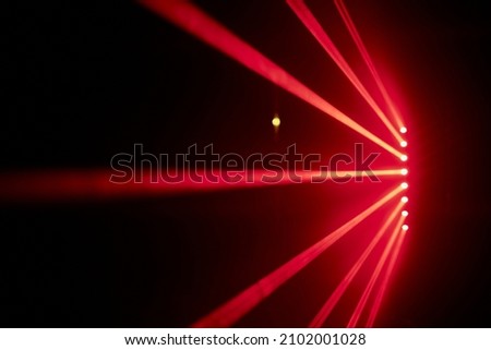 Bright red neon laser lights illuminate the darkness creating lines and triangle shapes in sci-fi effect. Royalty-Free Stock Photo #2102001028