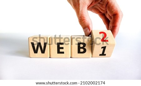 WEB 1 or 2 symbol. Businessman turns a wooden cube and changes words WEB 1 to WEB 2. Beautiful white table, white background, copy space. Business, technology and WEB 1 or 2 concept.