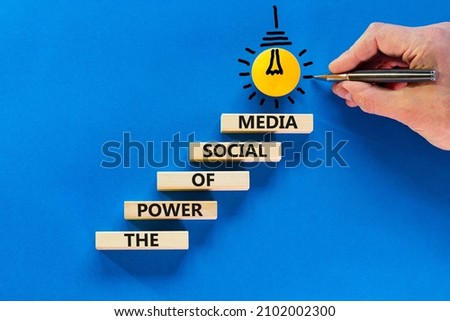 Power of social media symbol. Wooden blocks with words The power of social media. Light bulb icon. Businessman hand, pen. Blue background, copy space. Business, power of social media concept.