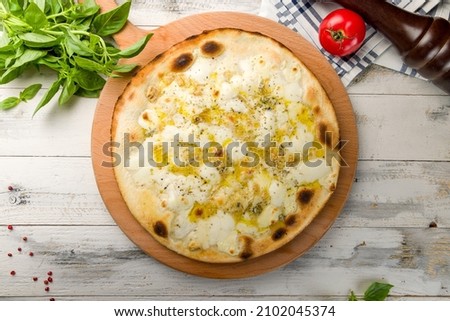 Pizza Quattro formaggi with four tips of cheese on wooden table top view on white wooden table
