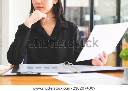 Cropped shot asian businesswoman sitting at office desk and checking business documents.