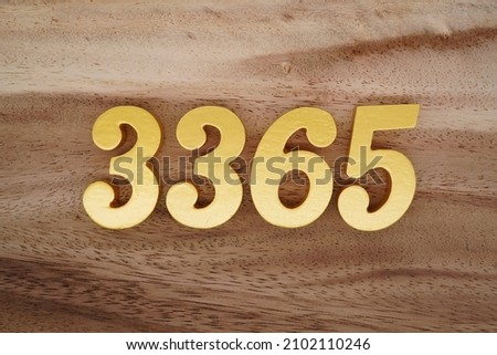 Golden Arabic numerals 3365 on a dark brown to white wood grain background.