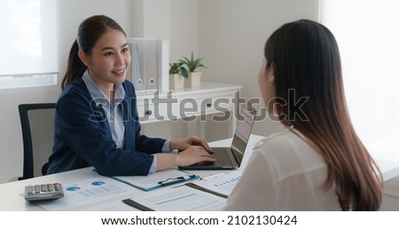 Asia real estate sale agent, stock market trader woman work at bank office talk in tax plan report. Lawyer help ask or advice lease on laptop desk typing fund loan data. Smile happy trust in HR job. Royalty-Free Stock Photo #2102130424