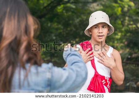 A nervous man is caught off guard by the unfounded accusations of another young lady. Mistaken identity. Outdoor scene. Royalty-Free Stock Photo #2102141203