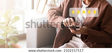 Customer pressing on smartphone with five stars icon for feedback review satisfaction service Royalty-Free Stock Photo #2102157517