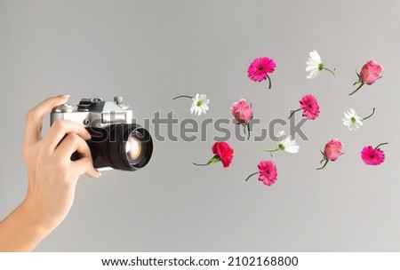 Floral composition with colorful flowers and old camera on grey background. Retro Valentine's Day or 8 March background.