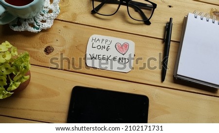 Happy long weekend text on wooden table. Selective focus.