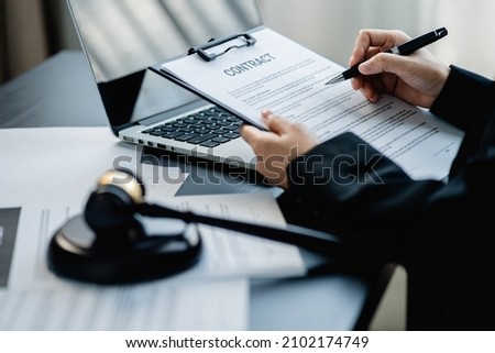 Businesswoman or Female lawyer drafting a business contract in a law firm. Consulting service legal concept. Royalty-Free Stock Photo #2102174749