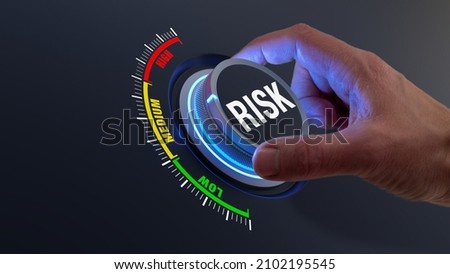 Risk management and mitigation to reduce exposure for financial investment, projects, engineering, businesses. Concept with manager's hand turning knob to low level. Reduction strategy. Royalty-Free Stock Photo #2102195545