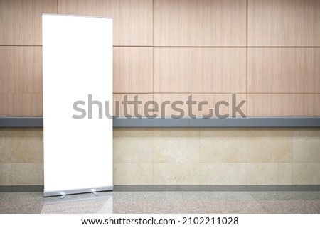 Blank roll up stand banner. Blank mockup for presentation isolated on wall background in hospital, hotel, airport. Royalty-Free Stock Photo #2102211028