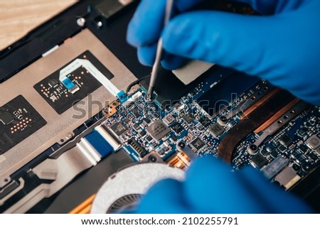 Close up laptop without cover inside disassembling in repair shop. Computer service engineer technician workplace repairing fixing broken components upgrade system, microelectronics maintenance Royalty-Free Stock Photo #2102255791