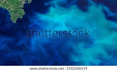 Aerial turquoise ocean photo from clear sky, top view of sea texture background, 16:9 ratio wallpaper, blooms of phytoplankton in the waters around England, Elements of this image furnished by NASA.
