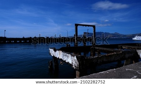 Remains and ruins of the abandoned concrete pier in a metropolitan harbor area