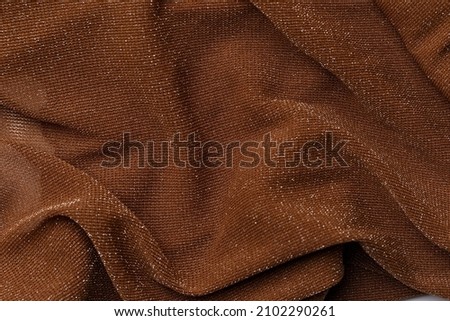Texture of brown shiny fabric, textile background, drapery and pleats on delicate fabric. Macrophotography. Close-up of rippled white silk fabric. Top view. Flat lay. Crumpled fabric background Royalty-Free Stock Photo #2102290261