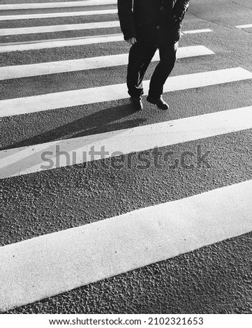 Asphalt textured background with legs casual citizen crossing road on pedestrian zebra crosswalk