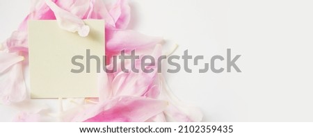 Tag mock up on pink flower petals. Greeting card banner. Organic products concept 