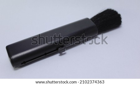 Lens pen and brush for cleaning camera, Close up of man hands cleaning camera lens with brush or lens pen cleaner. Photography equipment care.