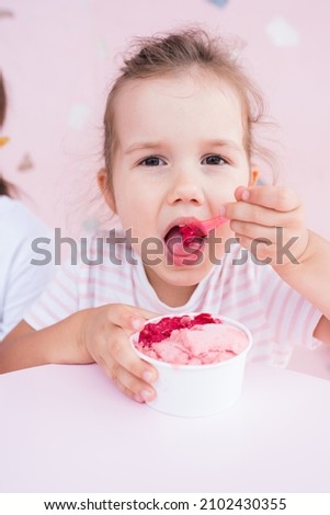 Summer food. Portrait of cute caucasian girl eating ice cream in cafe. Happy kid having sweets in gelateria. Childhood concept. Selective focus