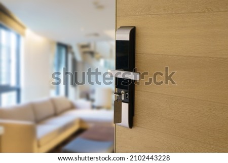 Digital Door handle or Electronics knob  for access to room security, Door wooden half opening through interior living room background, selective focus                     