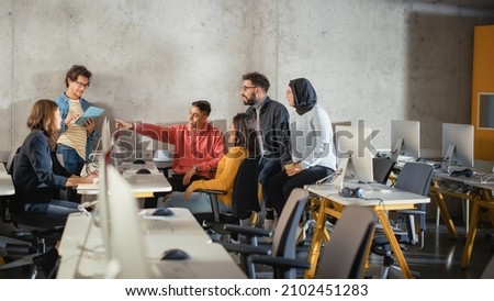 Diverse Multiethnic Group of Female and Male Students Sitting Together in Infographics Room, Collaborating on a School Project. Young Scholars Talking, Study Software Development or Computer Science. Royalty-Free Stock Photo #2102451283